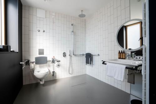 慕尼黑GREFIS Hotel的一间带卫生间、水槽和镜子的浴室