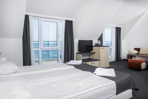 洛泽内茨Family Hotel Sunrise的酒店客房设有两张床和大窗户。