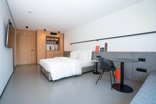 慕尼黑GREFIS Hotel的一间卧室配有一张床、一张桌子和一张桌子