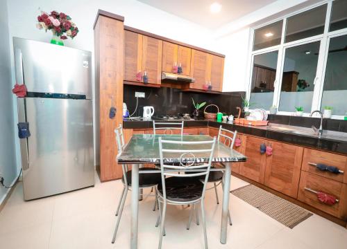 卡图纳耶克Howick Residence的厨房配有桌椅和冰箱。
