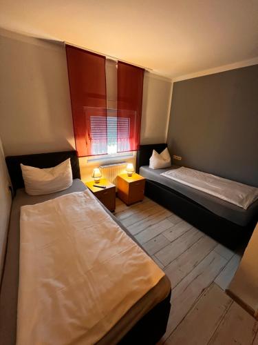 克桑滕斯比肯曼娜兰德宫酒店的小房间设有两张床和窗户