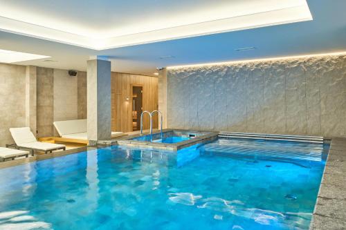 布克维Fomich Residence的游泳池位于酒店带大型蓝色浴缸的客房