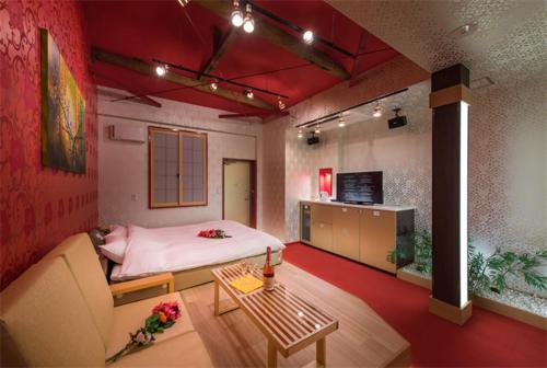 八王子市ホテル 鳳凰 大人専用的客房设有床、沙发和桌子。