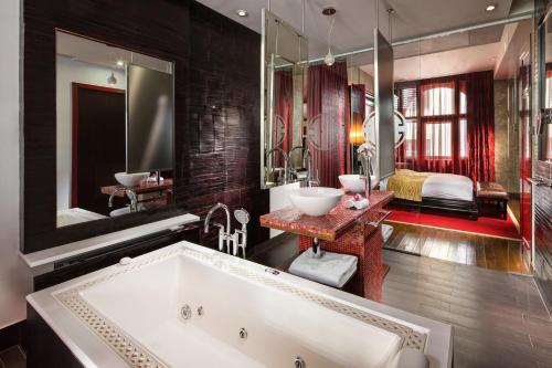 布拉格布拉格佛陀酒吧旅店的一间带大浴缸的浴室和一间卧室