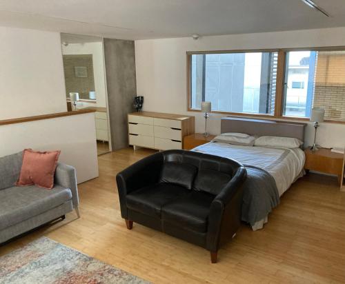 伦敦Loft in Haggerston的一间卧室配有一张床、一把椅子和一张沙发