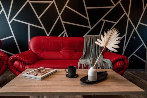 AugšlīgatneAlejas apartamenti的客厅配有红色的沙发和桌子