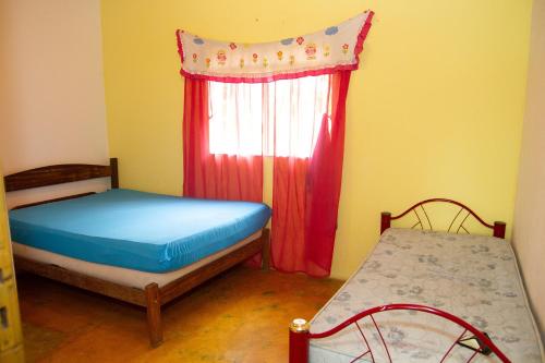 贝廷Chacara com WiFi de frente a lagoa em Betim MG的一间卧室设有两张床和窗户。