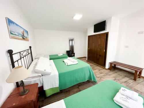 罗尔丹Nuevo Hotel Parador的一间卧室配有绿色和白色的床以及电视。