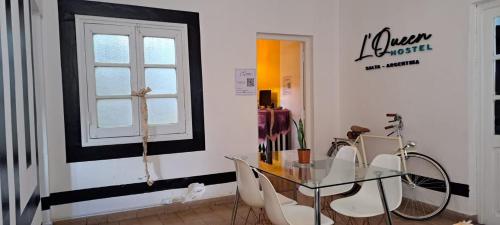 萨尔塔Hostel LQueen 1的一间设有玻璃桌和椅子的用餐室