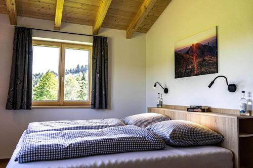上施陶芬Lohansler Hütte的一间卧室配有带两个枕头的床和窗户