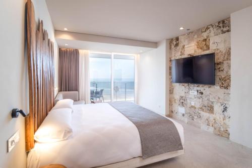 加的斯Cádiz Bahía by QHotels的一间卧室设有一张大床,墙上设有一台电视机
