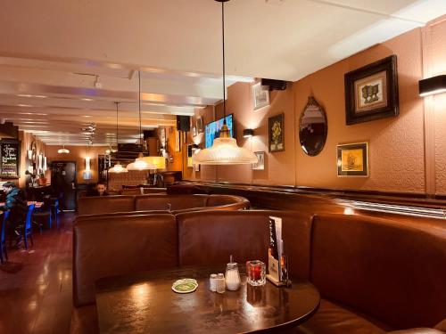 阿姆斯特丹老城区酒店的一间酒吧,配有棕色皮革座椅和桌子