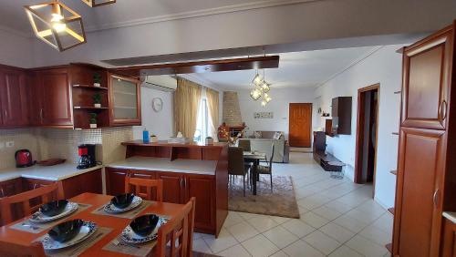 斯巴达Makarios Apartment Near Athens Aiport的厨房以及带桌椅的起居室。