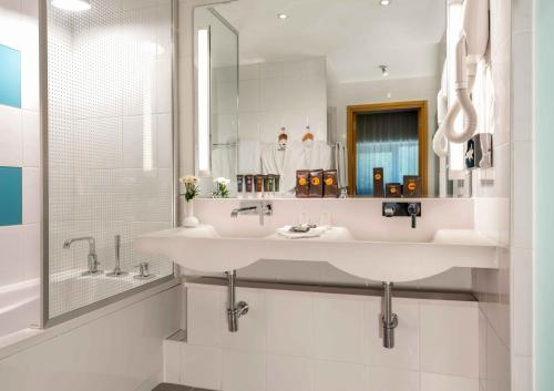 加济安泰普加济安泰普诺富特酒店的白色的浴室设有水槽和镜子
