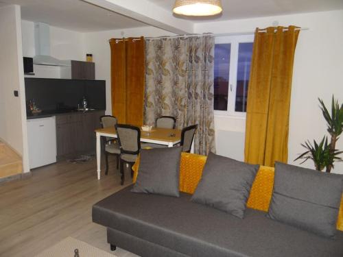 马尔桑奈拉科特Cosy Loft - Appartement de charme的客厅配有沙发和桌子