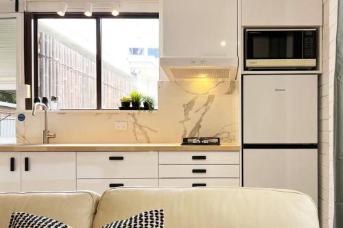 珀斯Studio C by Breckler Park的白色的厨房配有沙发和微波炉