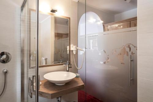 塞尔瓦迪加尔代纳山谷Garni Schenk的一间带水槽和玻璃淋浴的浴室