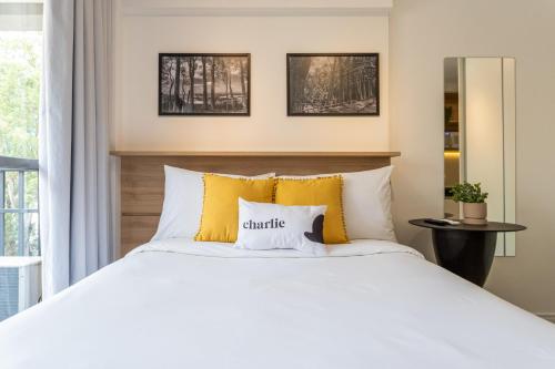 圣保罗Smart Charlie Parque Augusta Mackenzie的一间卧室配有白色床和黄色枕头
