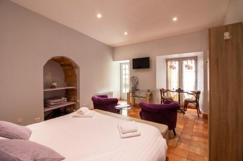 萨尔拉拉卡内达L'Appartement du "Coup de Coeur de Sarlat"的一间卧室配有两张床和一张桌子及椅子