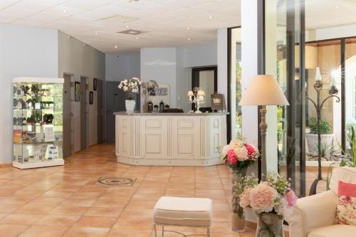 卡尔卡松Hôtel La Bastide Saint Martin的一间设有花店的房间,里面配有沙发和鲜花