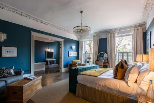 切尔滕纳姆三十八号公园住宿加早餐旅馆的卧室拥有蓝色的墙壁,配有一张床和一张沙发