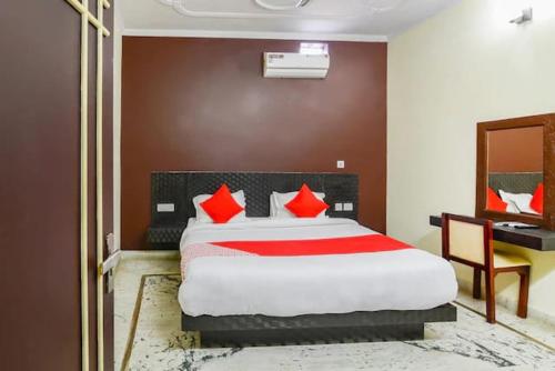 兰纳加Corbett Wildlife Homestay的一间卧室配有一张带红色枕头的床和一张书桌