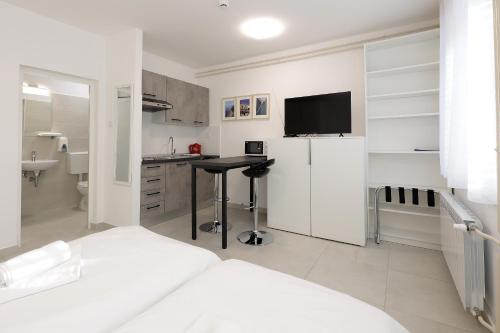 里耶卡Rijeka Budget Rooms的白色的客房设有一张床和一间带冰箱的厨房