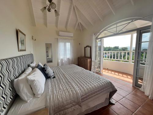 Bois dʼOrangeStunning 4-Bed Villa in Gros Islet St Lucia的一间卧室设有一张床和一个大窗户