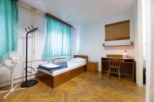 里耶卡Rijeka Budget Rooms的一间卧室配有一张床、一张桌子和风扇