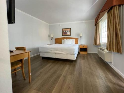 旧金山Motel 6 San Francisco CA Lombard Street的酒店客房配有一张床、一张书桌和一张西德西德西德西德床