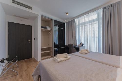 扎达尔Sky & Sun Luxury Rooms with private parking in the garage的一间卧室设有两张床和大窗户