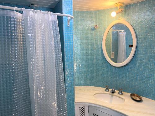 布希奥斯Praia dos Ossos Guest House - Búzios com pé na areia的带淋浴、水槽和镜子的浴室