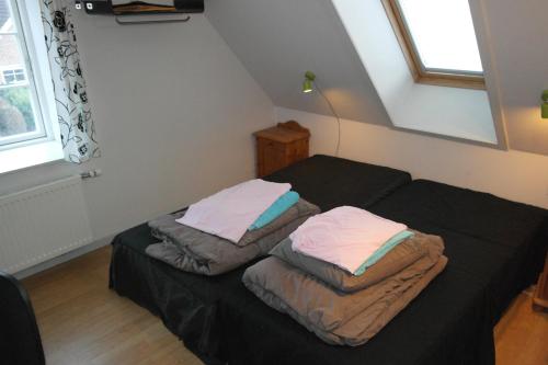 GuldborgPostholderens sted的一间卧室配有两张床、床单和枕头