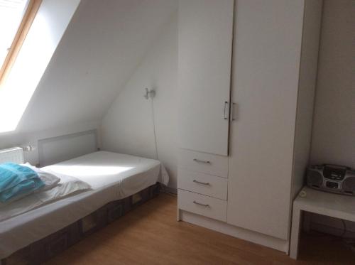 GuldborgPostholderens sted的一间卧室配有床和白色橱柜