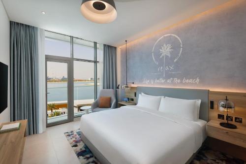 迪拜NH Collection Dubai The Palm的一间卧室配有一张床、一张书桌和一个窗户。