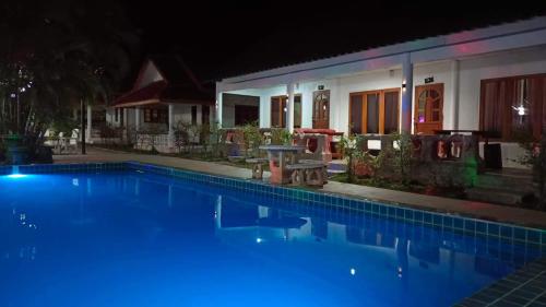 拜县PaiFamilyRESORT的夜晚的蓝色游泳池与房子