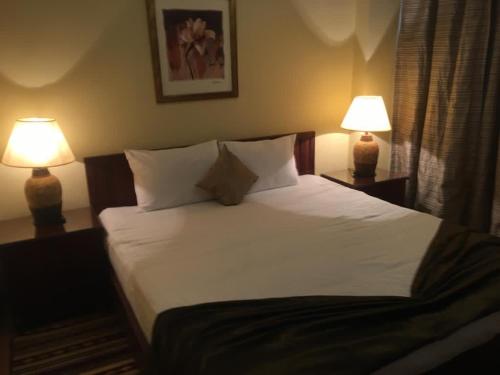 加利布港Marina residence Chalet port ghalib的一张位于酒店客房的床位,配有两盏灯