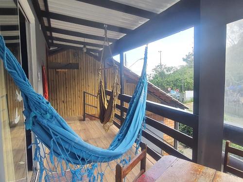 邦比尼亚斯Residencial Bombinhas Pé na Areia的窗户客房内的蓝色吊床