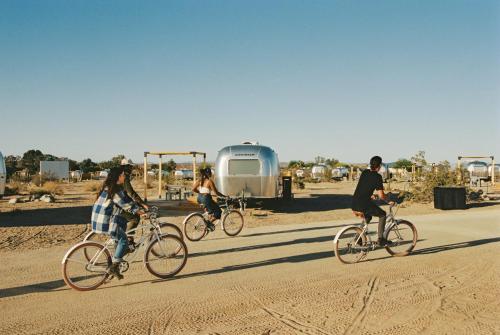 约书亚树AutoCamp Joshua Tree的一群人骑着自行车在土路上