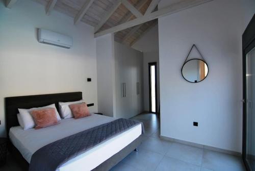 凯法利尼亚岛Villa Katerina Kefalonia的一间卧室配有一张大床和镜子