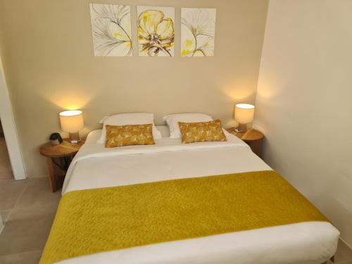 勒马兰La Villa Baie du Marin的一间卧室配有一张带两盏灯的大型白色床。