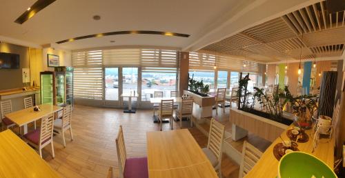 莫斯塔尔Hotel Rivero A&S的餐厅设有桌椅和大窗户。