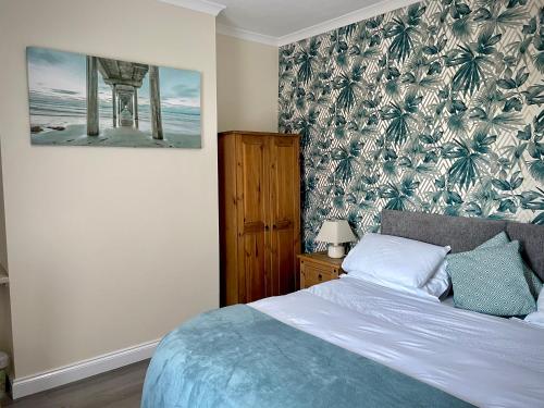 MonkwearmouthMilburn Cottage 2- Luxury Accommodation的卧室配有一张床,墙上挂着一幅画