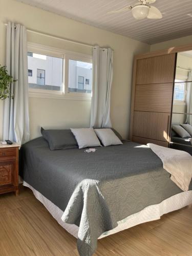 邦比尼亚斯Apartamentob301 coliving bombinhas的一间卧室设有一张大床和两个窗户。