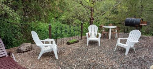 科尔多瓦Los Cedros的一组白色的椅子、一张桌子和一个烧烤架