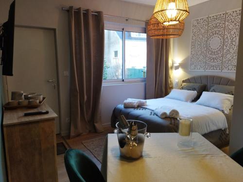 坎佩尔La Petite Perle de Quimper的酒店客房配有一张床和一张桌子,桌子上装有四面 ⁇ 