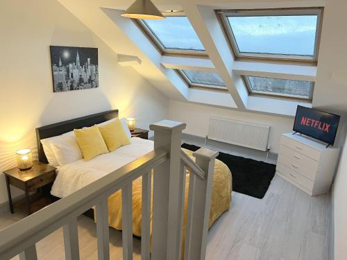 北安普敦New Two Bedroom Premium Apartment - Skylight - Northampton Town Centre的阁楼卧室配有1张床和电视