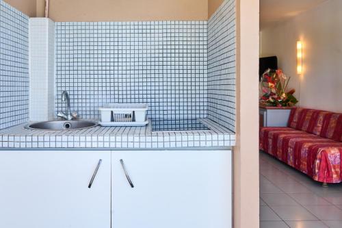 勒迪亚芒Diamant Beach的厨房配有水槽和红色沙发