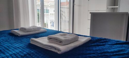 格兰阿利坎特Bungalow Deluxe Gran Alacant的蓝色床上的两条毛巾,带窗户