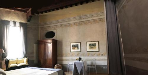 比萨Domus '400的一间卧室设有两张床、一张桌子和一个窗口